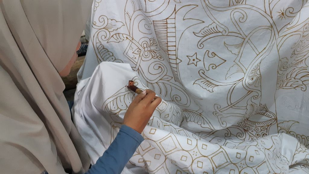 Pembatik sedang mengerjakan kain batik yang didesain oleh Dian Prymadika, di Batik Mahkota Laweyan, Kota Surakarta, Jawa Tengah, Jumat (30/9/2022) siang. Dian merupakan pembatik difabel yang berkarya di Batik Toeli Laweyan. Perusahaan batik tersebut mempekerjakan sejumlah difabel tuli lain seperti Dian.