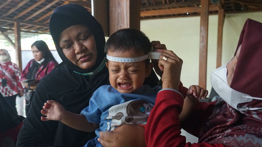 Seorang anak diukur lingkar kepalanya saat mendapatkan pelayanan di Posyandu Mawar Merah, Dusun Klangon, Sedayu, Bantul. DIY, Jumat (10/2/2023). 