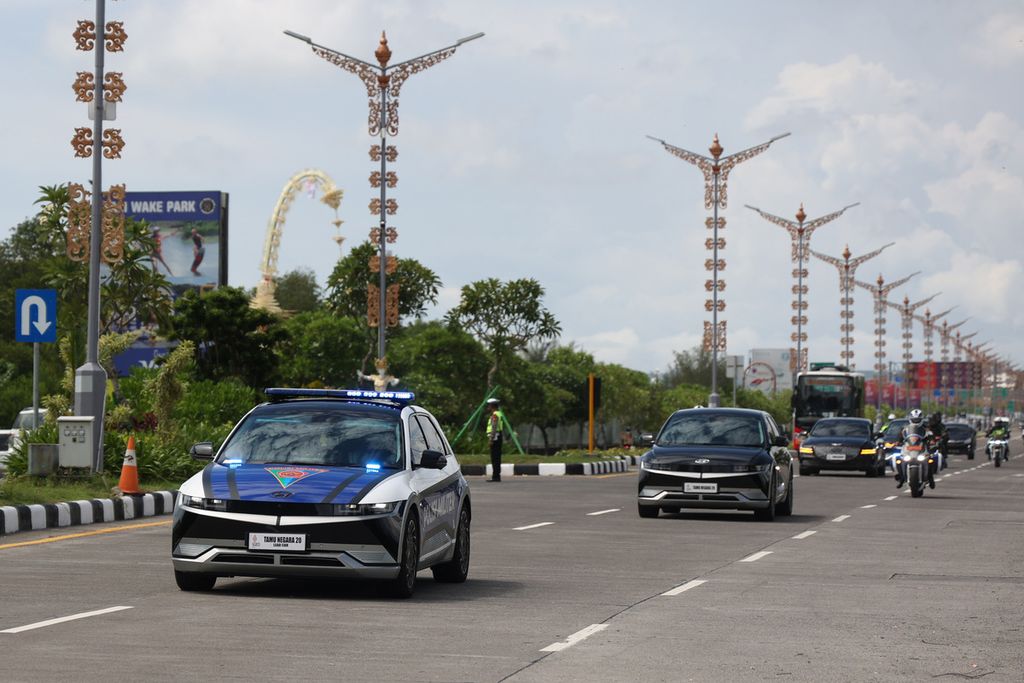Electric cars used to escort and transport delegation members of the participating countries in the G20 Summit pass on Jalan I Gusti Ngurah Rai. 