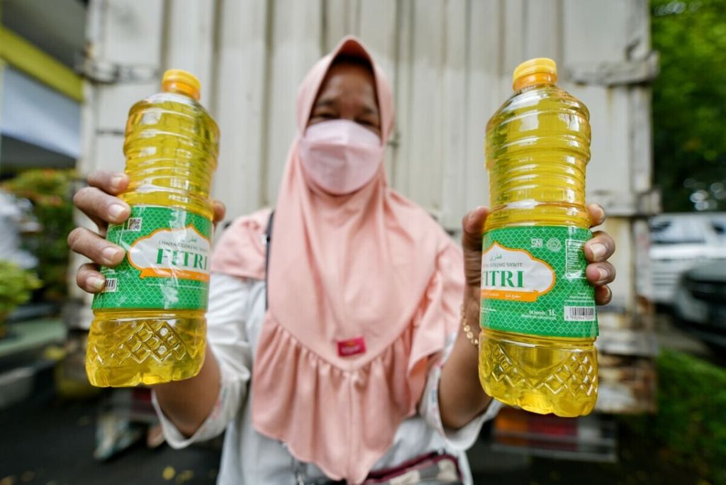 Warga memperlihatkan minyak goreng yang dibeli saat Pasar Murah Minyak Goreng di Kota Bekasi, Jawa Barat, Selasa (11/1/2022).