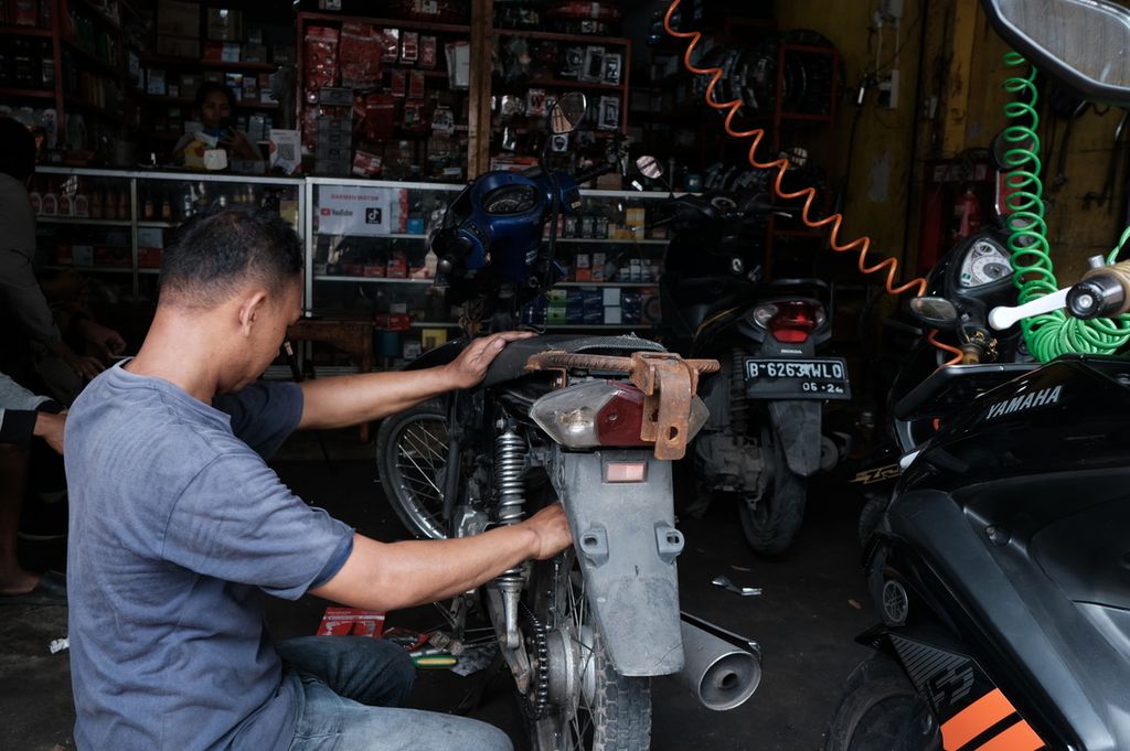 Seorang montir sedang menangani sepeda motor di sebuah bengkel di kawasan Jakarta Barat, Jakarta, Senin (17/10/2022).