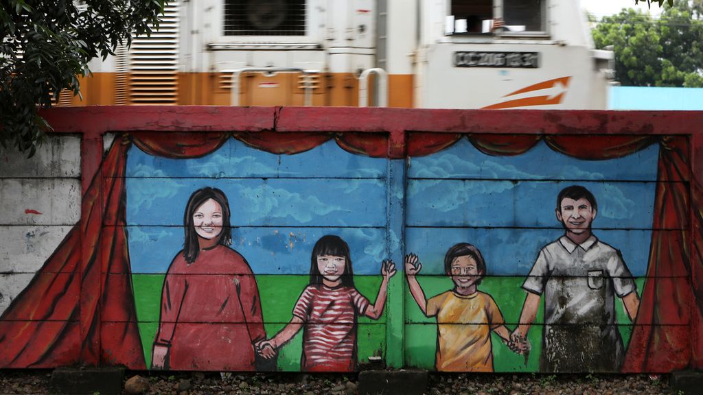 Mural berisi pesan gambaran keluarga bahagia di Jalan Bekasi Timur Raya, Jakarta Utara, Kamis (20/2/2020). 