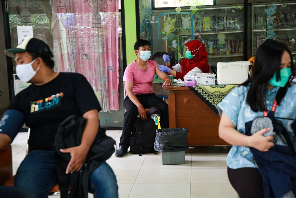  Residents receive the third dose of Covid-19 vaccine or booster at RPTRA Gondangdia, Central Jakarta, Monday (28/3/2022). People's interest increased to get booster vaccines after the government announced complete vaccinations as a condition for going home for Eid.