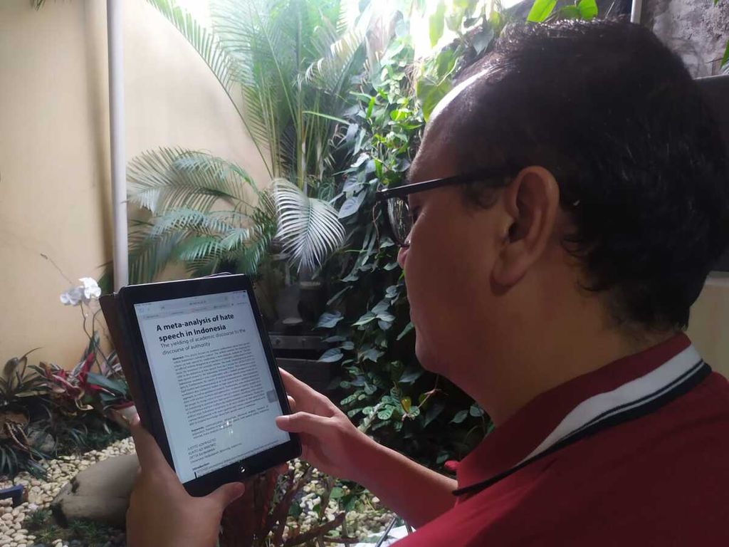 Dosen Metode Kuantitatif Fakultas Ilmu Komunikasi Universitas Padjadjaran S Kunto Wibowo membaca tulisan yang dimuat di jurnal lewat gawainya di Bandung, Jawa Barat, Jumat (11/2/2022).