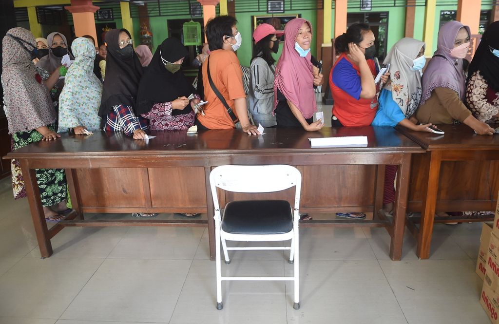 Warga antre saat Operasi Pasar Minyak Goreng di Kantor Kecamatan Waru, Kabupaten Sidoarjo, Jawa Timur, Senin (24/1/2022).  