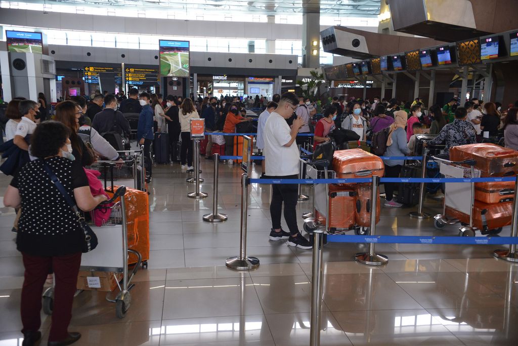 Sejumlah calon penumpang pesawat menunggu antrean di loket pelaporan keberangkatan di Terminal 3 Bandara Internasional Soekarno-Hatta, Tangerang, Banten, Selasa (20/12/2022). 