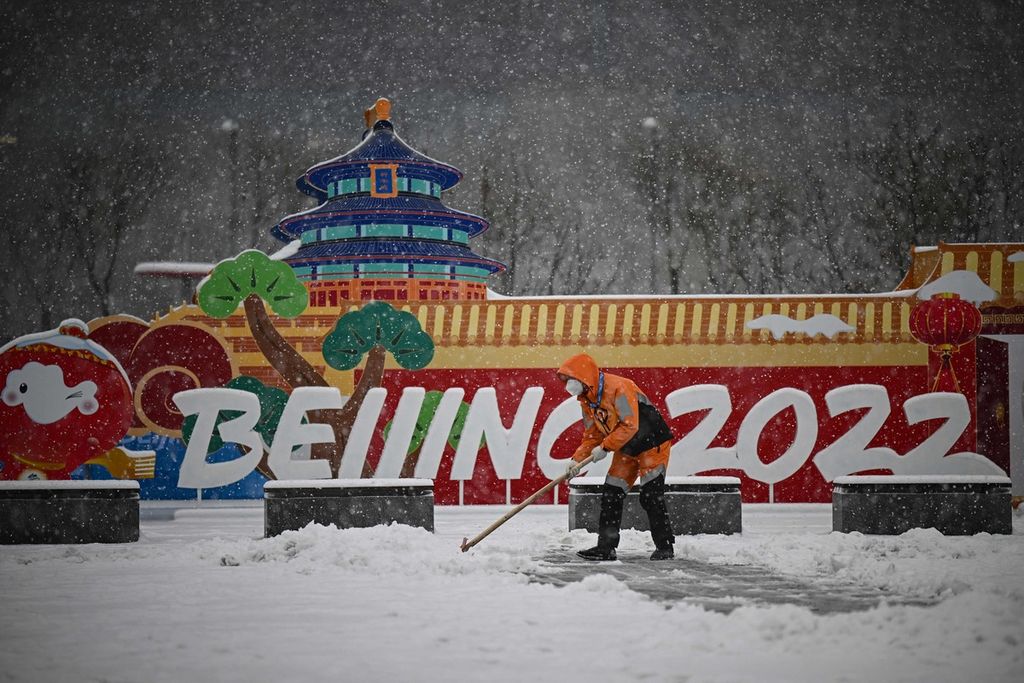 Seorang pekerja sedang membersihkan salju di Beijing, China saat berlangsung Olimpiade Musim Dingin 2022 (13/2/2022)