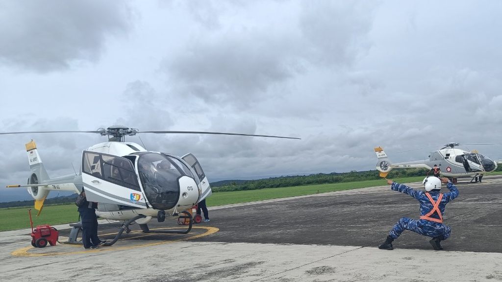 Marshaller atau juru parkir pesawat (kanan) beraksi di depan helikopter EC 120B Colibri di Pangkalan TNI Angkatan Udara (Lanud) Suryadarma, Subang, Jawa Barat, Kamis (2/3/2023).