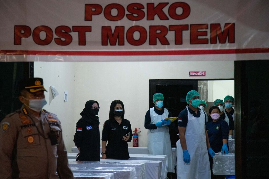 Polisi dan petugas medis di posko post mortem Rumah Sakit Bhayangkara Polda Kepulauan Riau menerima kepulangan jenazah pekerja migran dari Malaysia, Kamis (23/12/2021). 