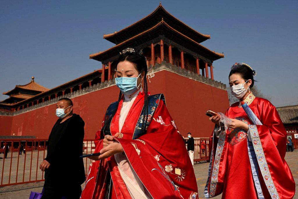 Perempuan mengenakan pakaian tradisional di dekat pintu masuk Kota Terlarang, Beijing, China, Selasa (8/3/2022). 