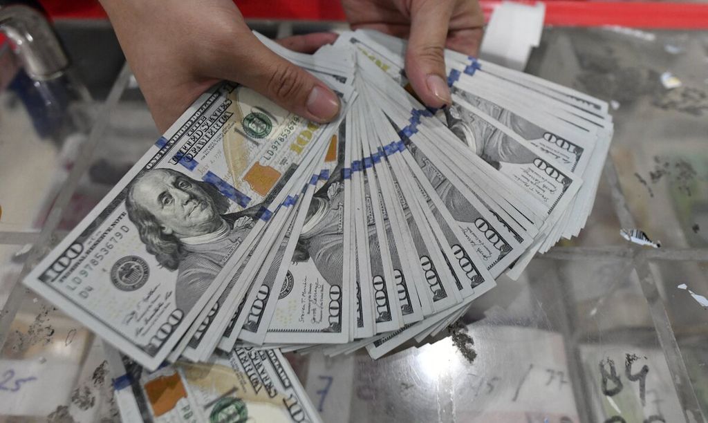  An officer shows the US dollar currency at the cash center of Bank Mandiri, Jakarta, Tuesday (5/4/2022).