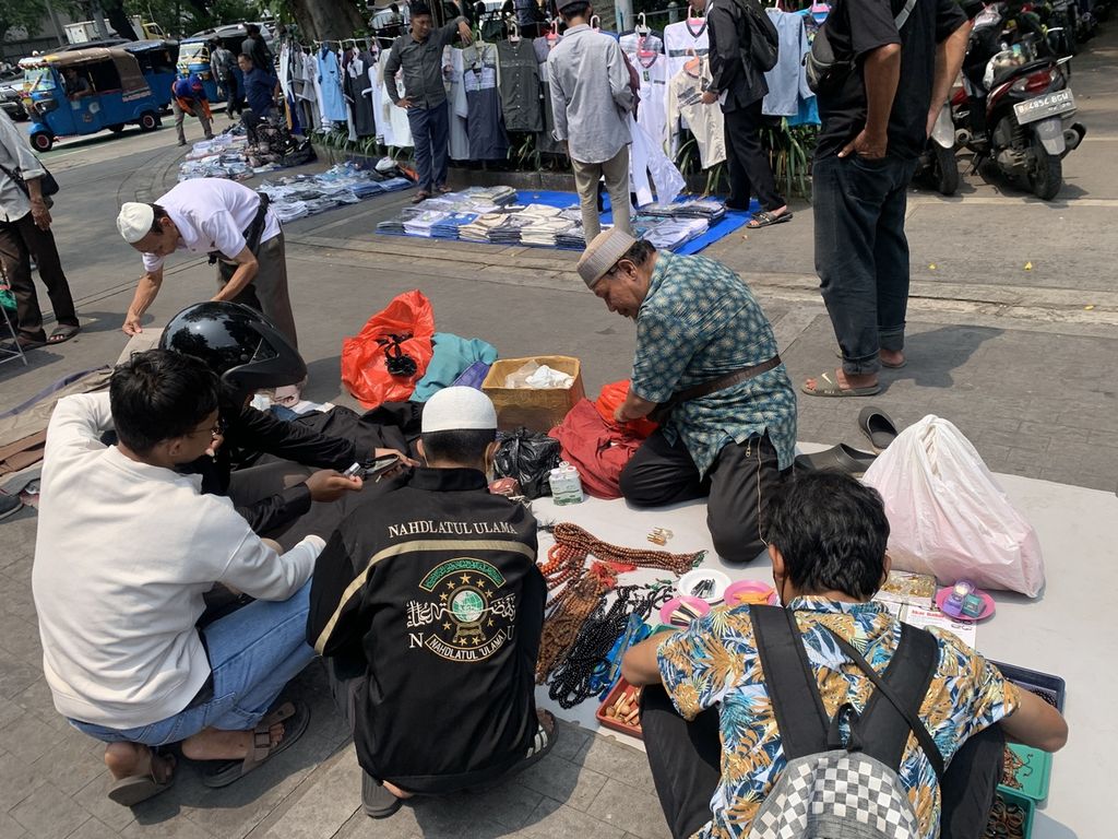 Suasana transaksi antara pedagang perlengkapan shalat dan calon pembeli yang merupakan jemaah shalat Jumat di Masjid Istiqlal, Jakarta, Jumat (24/3/2023).