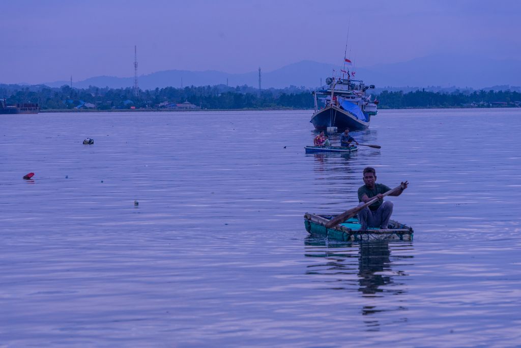 Arif (38), mendayung rakit menuju tepian Teluk Kendari, Sulawesi Tenggara, Senin (28/3/2022). 