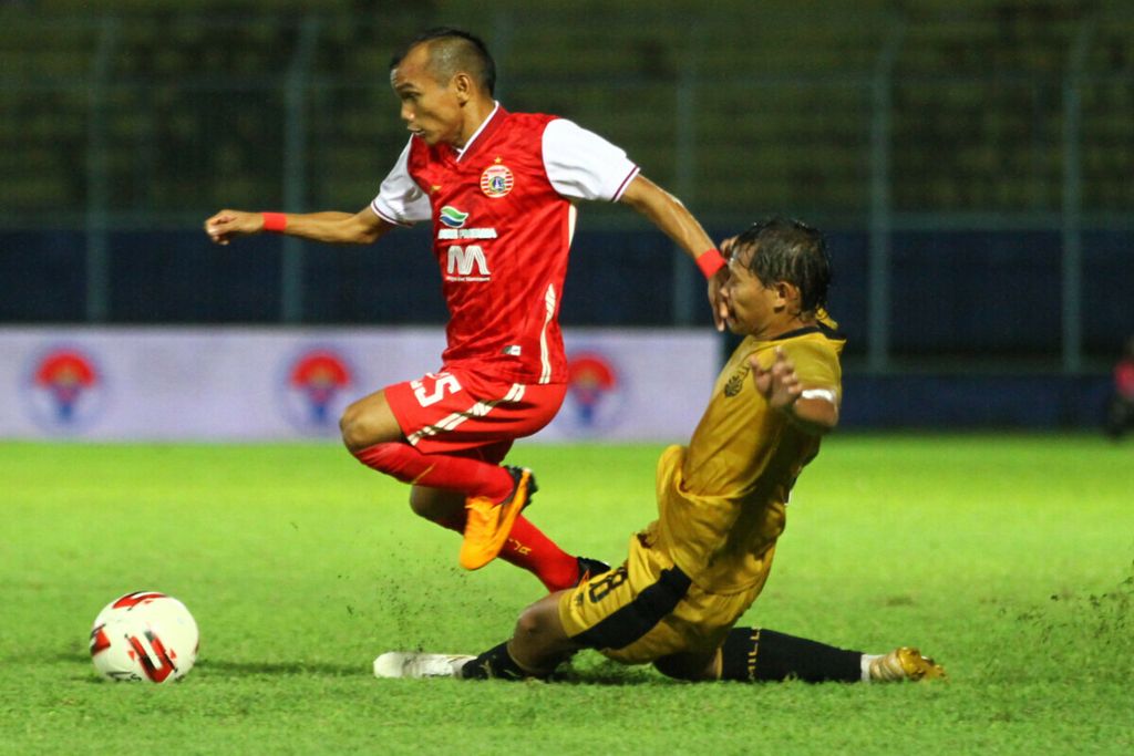 Pesepak bola Persija Jakarta, Riko Simanjuntak (kiri), berusaha melewati hadangan pemain Bhayangkara Solo FC, Mohammad Hargiyanto (kanan), dalam laga lanjutan Piala Menpora Grup B di Stadion Kanjuruhan, Malang, Jawa Timur, Rabu (31/3/2021).