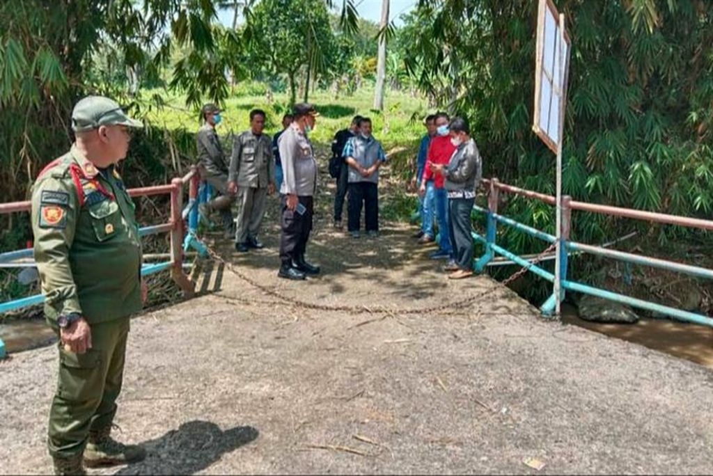 Petugas gabungan membuka portal di jalan alternatif di Desa Pandansari, Ciawi, Kabupaten Bogor, yang sempat dijaga oleh organisasi kemasyarakatan pekan ini. 