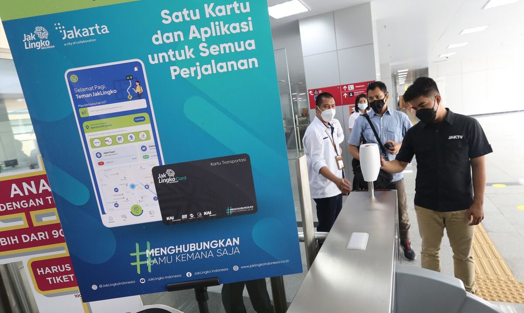 Rombongan jurnalis menempelkan kartu JakLingko pada mesin pemindai kartu JakLingko di Stasiun LRT Velodrome, Jakarta Timur, saat turut dalam uji coba penggunaan kartu JakLingko untuk empat jenis moda transportasi publik, Senin (4/10/2021). 