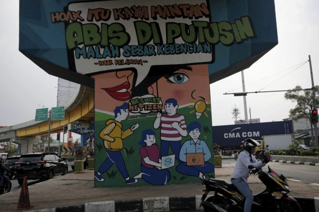 Warga melintasi mural berisi anjuran warga untuk hati-hati dengan hoaks di jalan layang Rawa Panjang, Kota Bekasi, Minggu (11/6/2021). Penyebaran berita hoaks dan perundungan siber yang tinggi menyebabkan Indonesia menjadi salah satu negara dengan tingkat keadaban yang rendah di dunia maya.