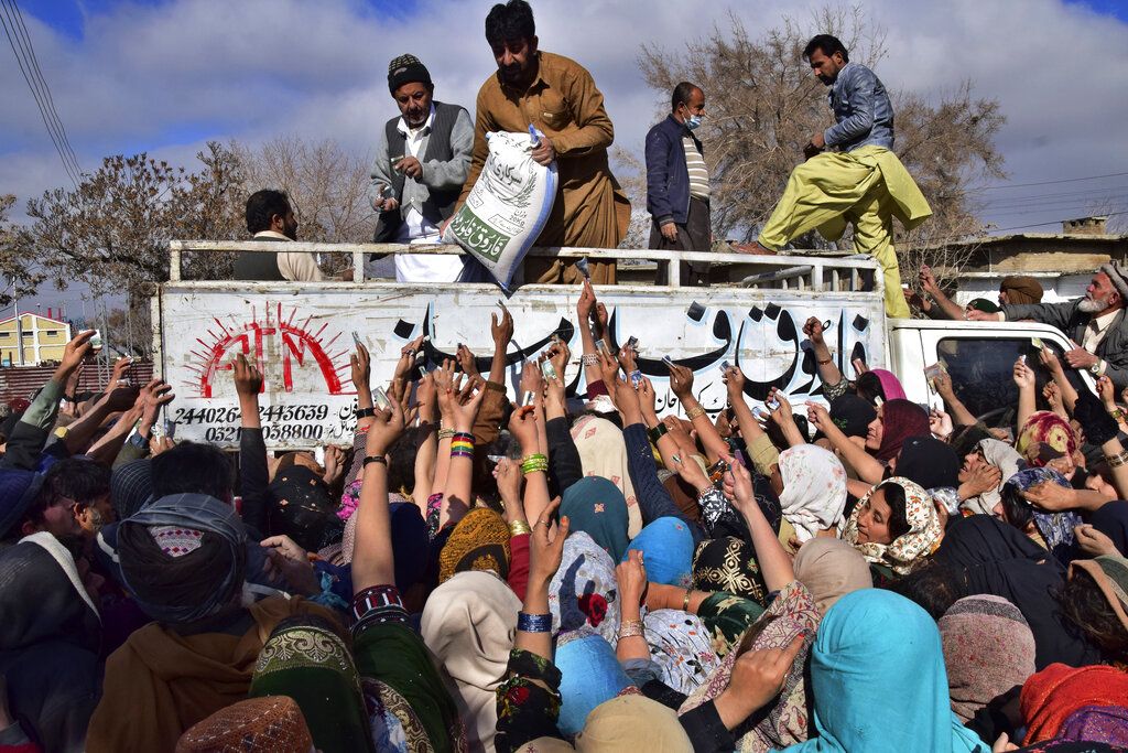 Orang-orang berusaha mendapatkan karung berisi gandum di Quetta, Pakistan, 12 Januari 2023. 