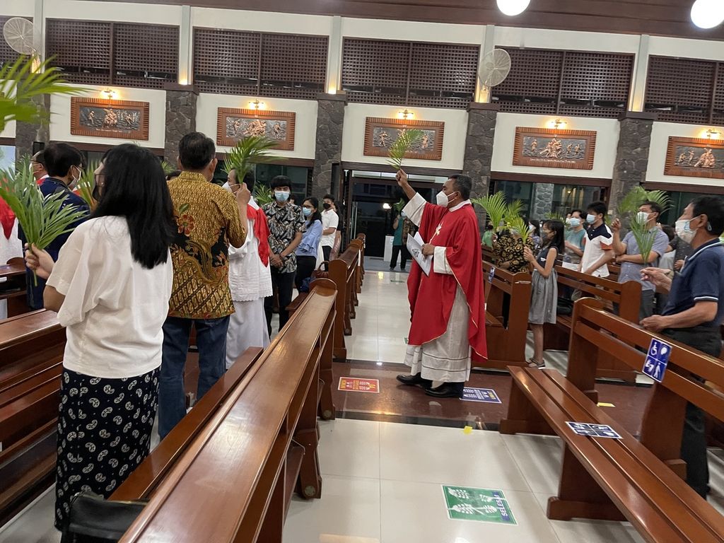 Daun palma umat diperciki air suci pada perayaan Misa Minggu Palma yang dipimpin Yoseph Jaga Dawan SVD di Gereja Katolik Roh Kudus, Surabaya, Sabtu (9/4/2022) petang.