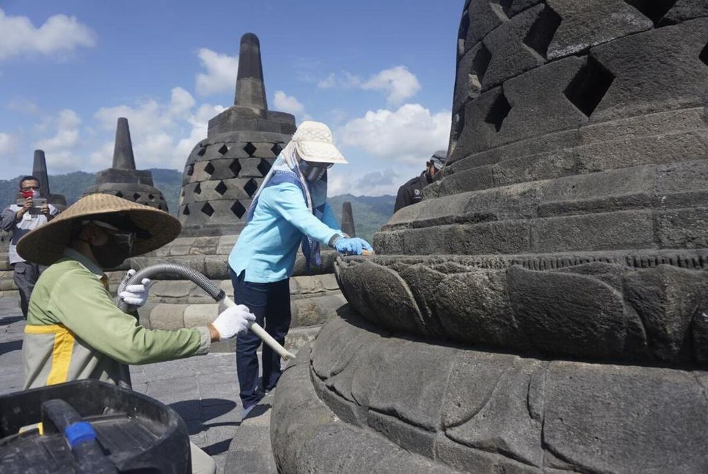 Sejumlah petugas dari Balai Konservasi Borobudur (BKB) membersihkan Candi Borobudur, Kabupaten Magelang, Jawa Tengah, dengan menggunakan penyedot debu, Senin (22/6/2020).