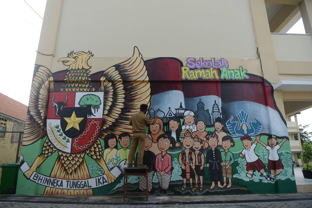 Guru seni lukis Mardani Eko menyelesaikan pembuatan mural bertema keberagaman di dinding gedung SD Negeri Cengklik, Banjarsari, Solo, Jawa Tengah, Senin (8/2/2021). Mural tersebut dibuat untuk menyampaikan pesan pentingnya menjunjung tinggi sikap saling menghormati keberagaman di lingkungan sekolah.