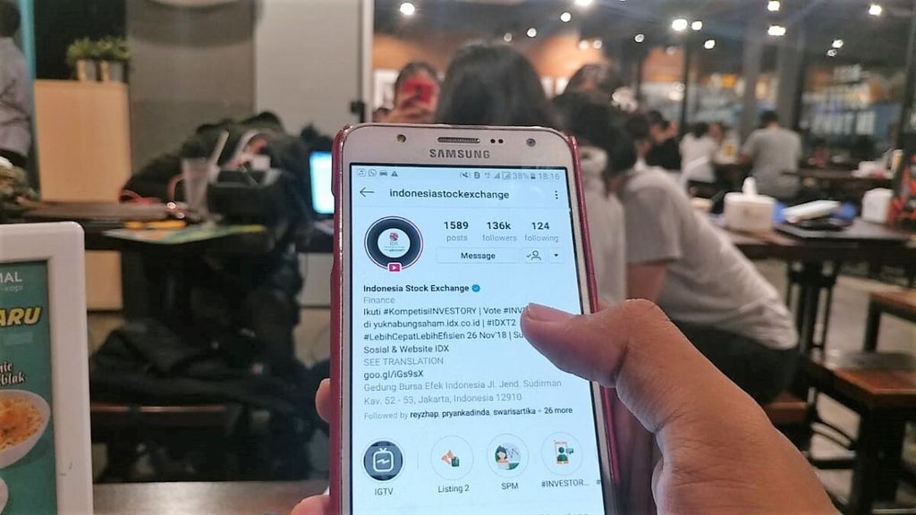 Seorang pekerja milenial sedang mencari informasi tentang pasar saham lewat Instagram melalui ponselnya di sebuah kafe di bilangan Jakarta Selatan.