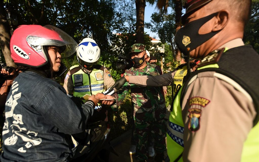 Petugas menindak pengendara yang tidak menggunakan masker saat Operasi Yustisi Pelanggar Protokol Kesehatan di Jalan Darmo, Surabaya, Senin (14/9/2020). 
