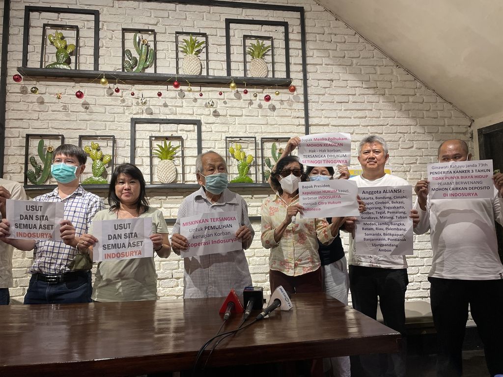 Para korban kasus gagal bayar Koperasi Simpan Pinjam Indosurya menunjukkan poster saat konferensi pers, di Jakarta, Minggu (18/12/2022). Mereka menuntut majelis hakim memutuskan agar aset terdakwa yang disita dikembalikan ke mereka, alih-alih diserahkan ke negara