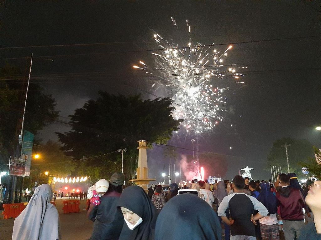 Sejumlah warga melihat pemandangan kembang api di langit di Alun-alun Magelang, Kota Magelang, Jawa Tengah, Minggu (1/5/2022).