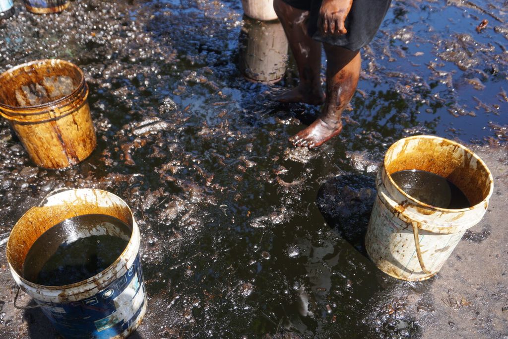 Warga mengumpulkan minyak mentah yang tumpah di perairan Nusakambangan untuk diambil oleh pihak Pertamina di sekitar Dermaga Wijayapura, Cilacap, Jawa Tengah, Selasa (28/6/2022). Ada sekitar 1.900 liter minyak yang tumpah mencemari permukaan perairan. 
