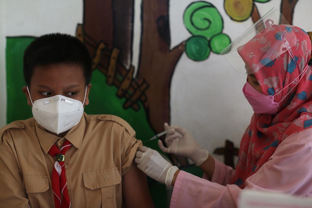 Pelajar menerima suntikan imunisasi <i>diphteria tetanus</i> (DT) yang diadakan oleh Puskesmas Rawa Bunga, Jatinegara, Jakarta Timur, Rabu (29/9/2021). Kegiatan ini diadakan dalam rangka bulan imunisasi anak sekolah. Imunisasi DT diberikan untuk mencegah beberapa penyakit infeksi, seperti difteri, tetanus, dan batuk rejan. Selain imunisasi, para pelajar juga diperiksa kesehatan dan kebersihan telinga, mulut, dan mata serta diberikan obat cacing.