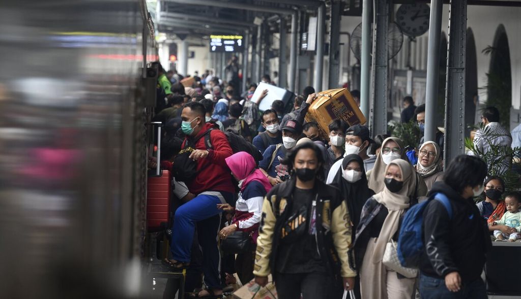Penumpang kereta api bersiap masuk ke gerbong kereta saat KA Brantas dengan tujuan Blitar telah tersedia di Stasiun Pasar Senen, Jakarta, Kamis (22/12/2022).