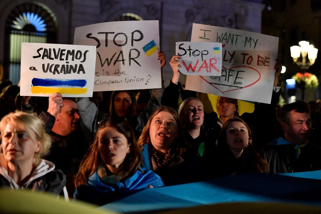 Demonstran memegang spanduk bertuliskan Hentikan Perang dan Ayo Selamatkan Ukraina selama protes terhadap operasi militer Rusia di Ukraina, di Barcelona, Spanyol, Kamis (24/2/ 2022). 