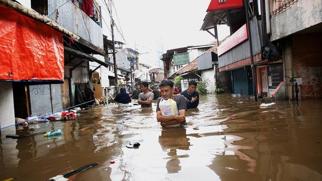 Warga menembus banjir akibat meluapnya Kali Krukut di Kelurahan Karet Tengsin, Tanah Abang, Jakarta Pusat, Selasa (25/2/2020). Banjir tidak hanya merendam sejumlah permukiman, tetapi juga memutus akses jalan di beberapa wilayah di Jakarta, Bekasi, dan Tangerang.