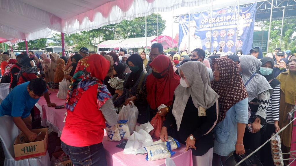 Warga antre membeli tepung terigu dan minyak goreng dalam kegiatan operasi pasar barang kebutuhan pokok di Banjarmasin, Kalimantan Selatan, Sabtu (28/1/2023). 