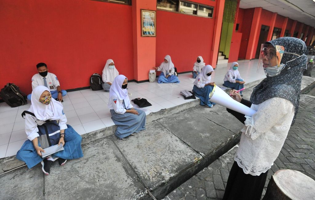 Guru mengajar siswa jurusan Kriya Tekstil SMK Negeri 12 Surabaya, Jawa Timur, Rabu (2/9/2020). Sekolah menengah kejuruan seni tersebut kembali menyelenggarakan sekolah tatap muka dan memberlakukan sistem sekolah bergilir bagi siswanya. Dalam satu hari dibagi dalam dua sif yang masing-masing hanya dihadiri oleh 300 siswa. Hal tersebut sebagai persiapan siswa kelas XI untuk magang serta persiapan tugas akhir siswa kelas XII. 