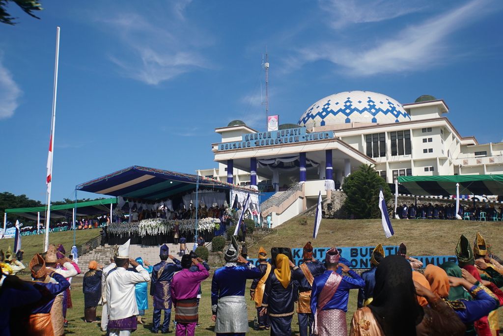 Warga mengikuti upacara bendera di halaman kantor bupati Bolaang Mongondow Timur, Kamis (21/7/2022), di Tutuyan, Bolaang Mongondow Timur, Sulawesi Utara, dalam perayaan hari jadi ke-14 kabupaten tersebut.