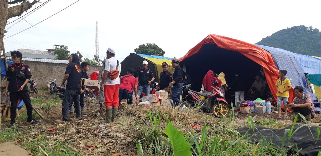 Sukarelawan mendistribusikan bantuan ke pengungsi gempa di Desa Ciputri, Kecamatan Pacet, Kabupaten Cianjur, Jawa Barat, Minggu (27/11/2022).