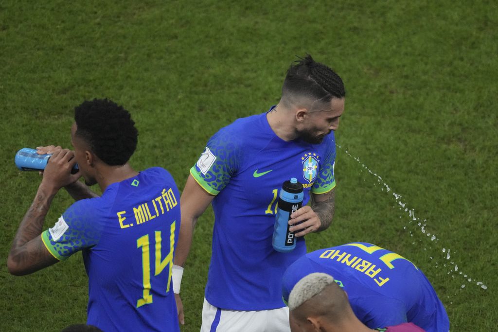 Pemain Brasil, Alex Telles, menyemburkan air minum saat bertanding melawan Kamerun di fase Grup G di Stadion Lusail, Qatar, Sabtu (3/12/2022) dini hari WIB.