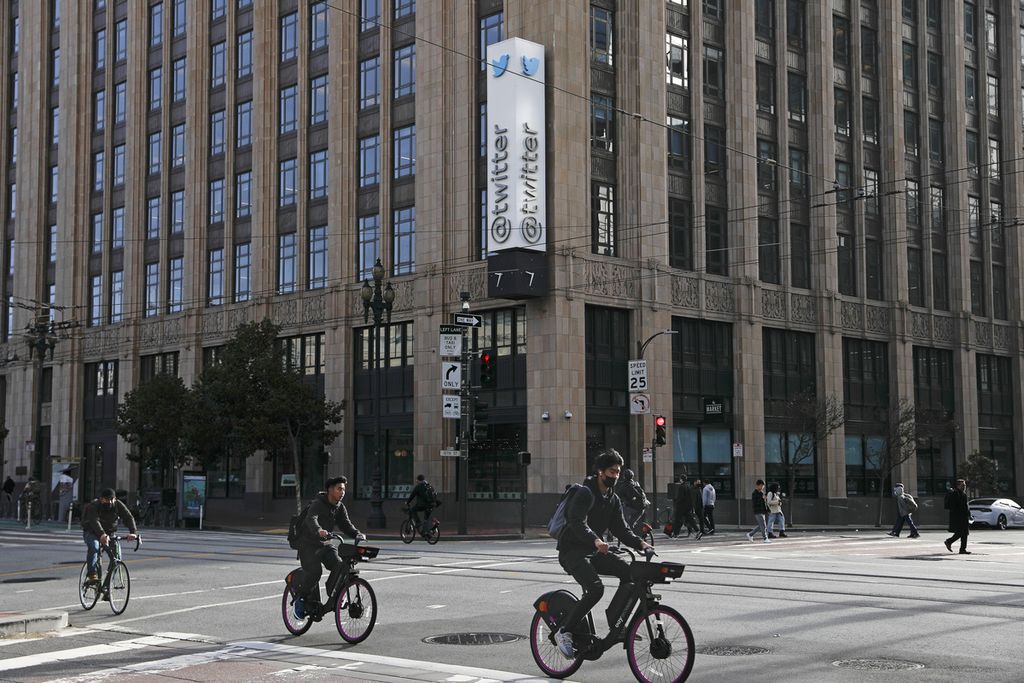 Sejumlah orang bersepeda di Market Street melewati Kantor Pusat Twitter di San Francisco, Jumat (4/11/2022). Twitter melakukan pemutusan hubungan kerja separuh dari pegawainya sebagai salah satu kebijakan Elon Musk, pemilik baru perusahaan media sosial itu. 