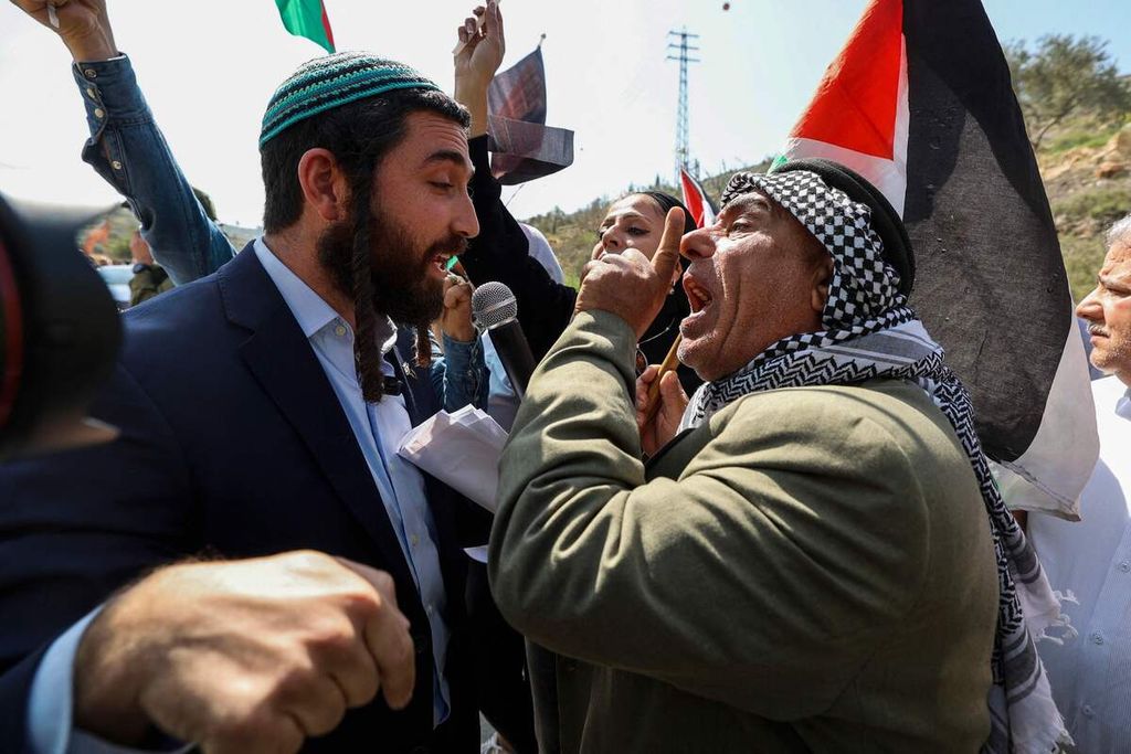 Anggota parlemen Israel (Knesset) dari Partai Zionisme Keagamaan, Tzvi Sukkot (kiri), berupaya menghentikan unjuk rasa damai warga Palestina dan aktivis Israel pro-perdamaian di gerbang masuk Huwara, wilayah pendudukan Tepi Barat, 3 Maret 2023. 
