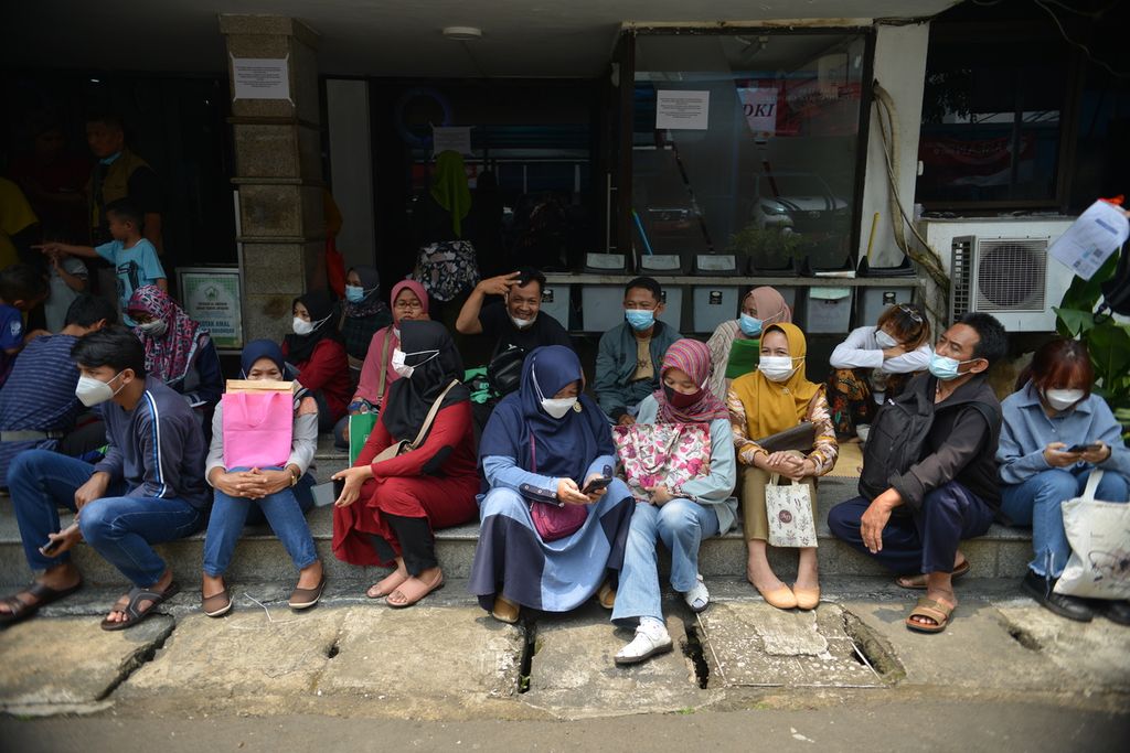 Sejumlah warga menunggu panggilan untuk memverifikasi pendaftaran program mudik Lebaran gratis 2023 di depan Kantor Dinas Perhubungan DKI Jakarta, Gambir, Jakarta Pusat, Jumat (24/3/2023).
