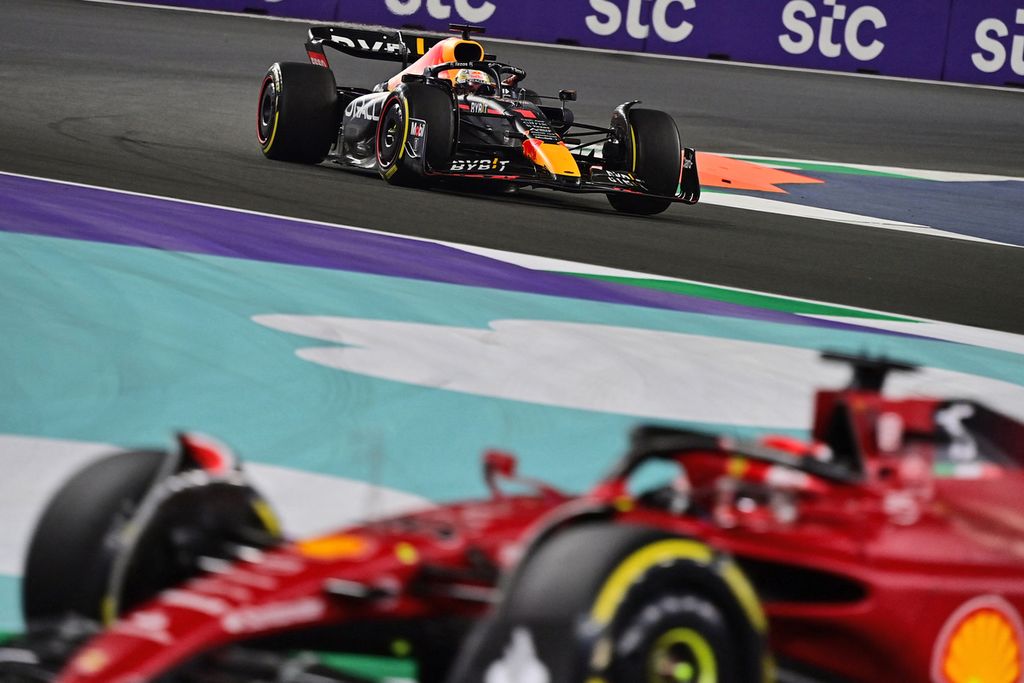 Pebalap Red Bull, Max Verstappen (belakang), memacu mobilnya dalam saat Grand Prix Formula 1 seri kedua di Sirkuit Corniche, Jeddah, Arab Saudi, Senin (28/3/2022) dini hari WIB. Start dari peringkat keempat, Verstappen berhasil menjadi juara melalui duel alot dengan pebalap Ferrari Charles Leclerc.
