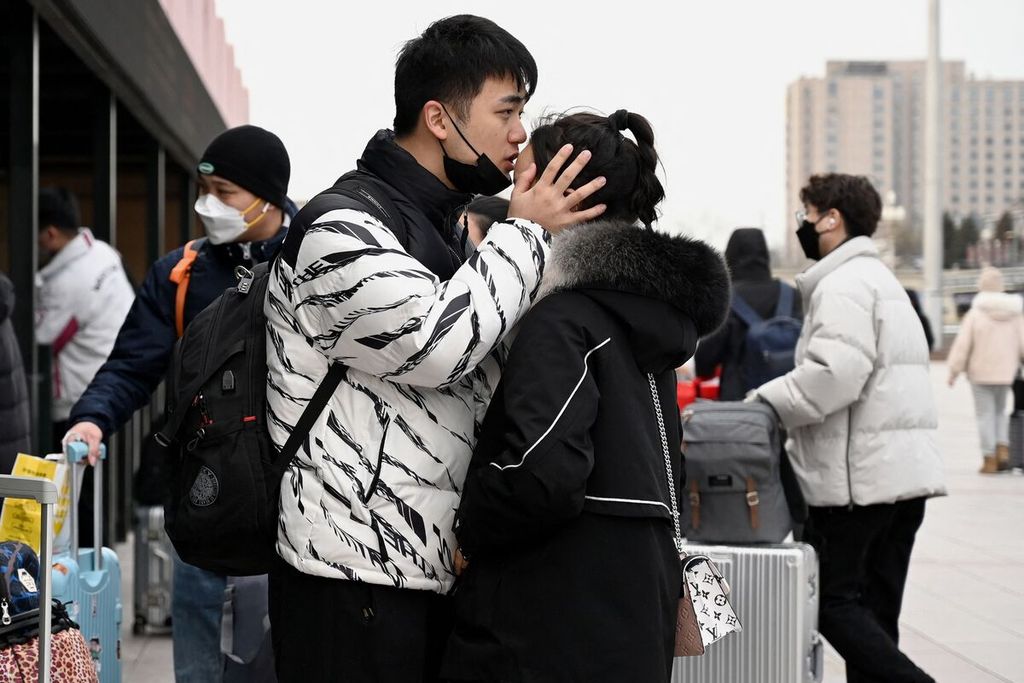 Sepasang laki-laki dan perempuan bersiap mudik dari Stasiun Kereta Beijing di Beijing, China, 26 Januari 2022, menjelang tahun baru Imlek.