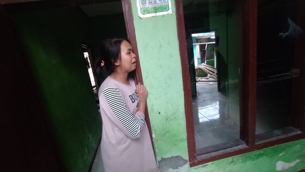 Siti Fatimah (27) berdiri di pintu rumahnya sembari menceritakan gempa yang menimpa rumahnya di Desa Pakuon, Sukaresmi, Cianjur, Jawa Barat, (26/11/2022). Klitik -<i>nya</i> pada kata rumah merupakan pengganti <i>ia/dia</i>.