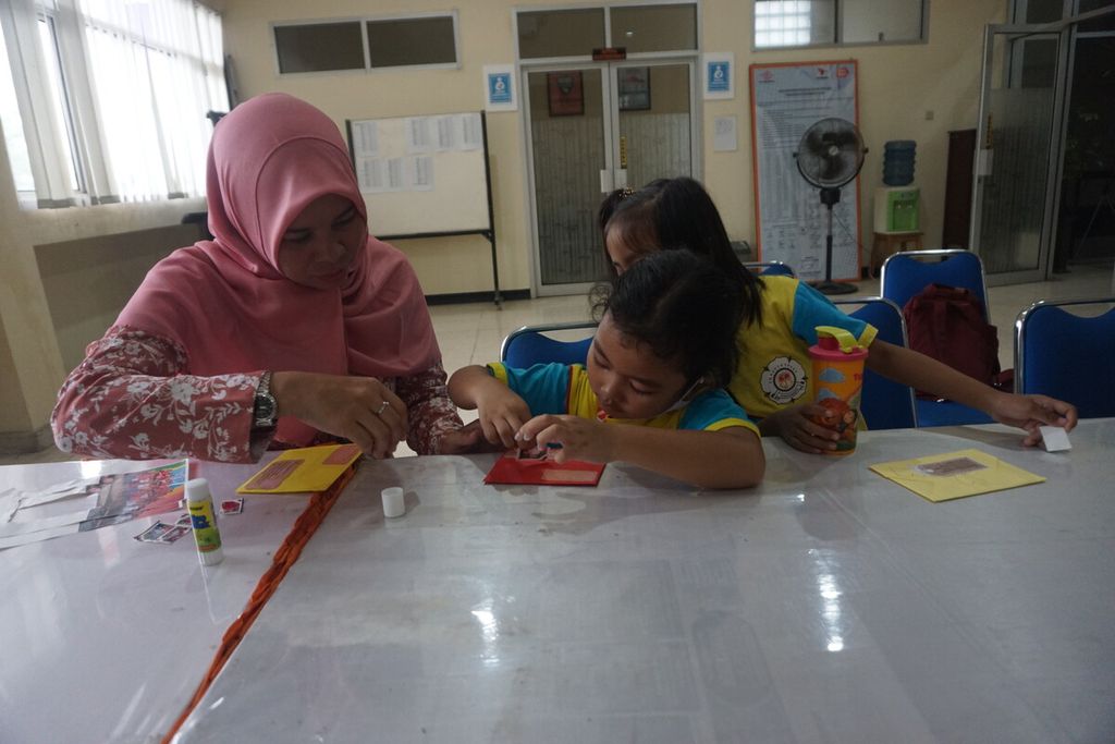 Anak-anak TK Santo Yosep menempel prangko bergambar foto diri mereka saat berkunjung ke Kantor Pos Purwokerto di Kabupaten Banyumas, Jawa Tengah, Kamis (2/3/2023).