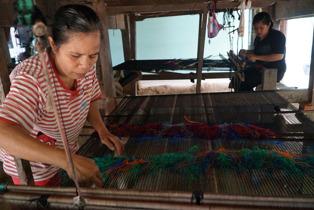 Seorang penenun songket silungkang tengah merapikan benang songket di salah satu sentra songket di Desa Lunto Timur, Sawahlunto, Sumatera Barat, Rabu (16/10/2019) sore. Di luar proses pemintalan benang dan pembuatan dasar songket, butuh waktu sekitar 2-3 hari untuk menenun satu lembar songket.