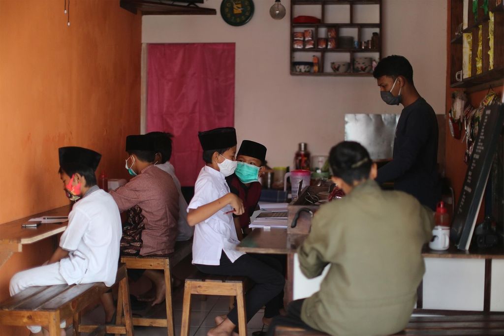 Sejumlah pelajar tingkat SD dan SMP memanfaatkan warung kopi yang menyediakan jaringan nirkabel koneksi internet gratis untuk belajar di Pondok Aren, Tangerang Selatan, Banten (30/7/2020). 