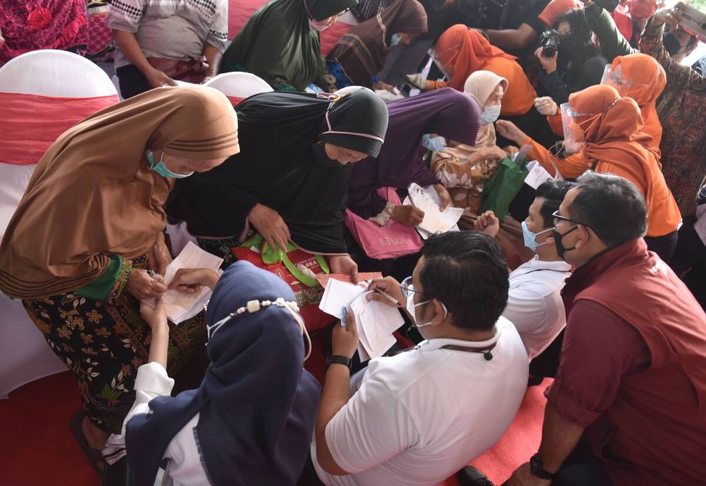 Petugas mengurus pencairan uang warga dalam penyaluran bantuan Program Keluarga Harapan, bantuan pangan nontuna,i dan bantuan langsung tunai (BLT) minyak goreng di Kantor Kecamatan Rungkut, Kota Surabaya, Jawa Timur, Sabtu (16/4/2022). 