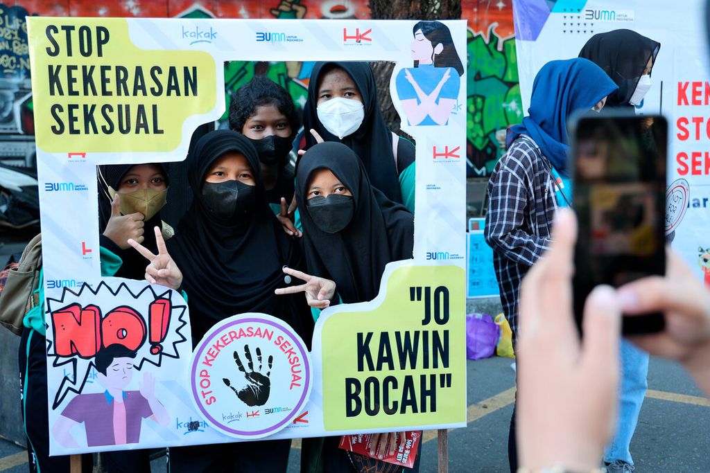 Anak-anak berfoto di antara bingkai yang berisi pesan untuk menghentikan berbagai bentuk kekerasan pada anak di Jalan Slamet Riyadi, Kota Surakarta, Jawa Tengah, Minggu (24/7/2022). 